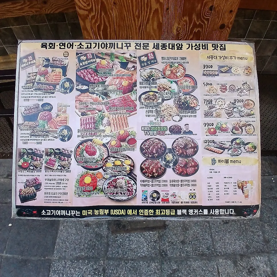 Outdoor menu board listing yukhoe, salmon, and beef yakiniku