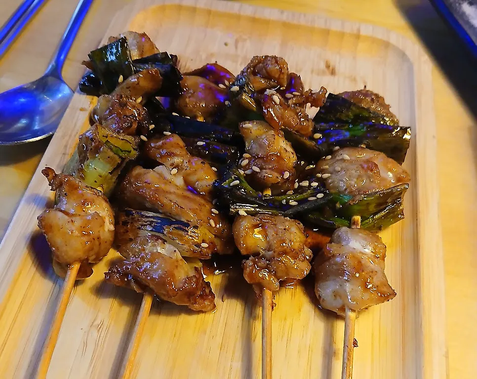 Close-up of fried chicken skewers with a smoky char