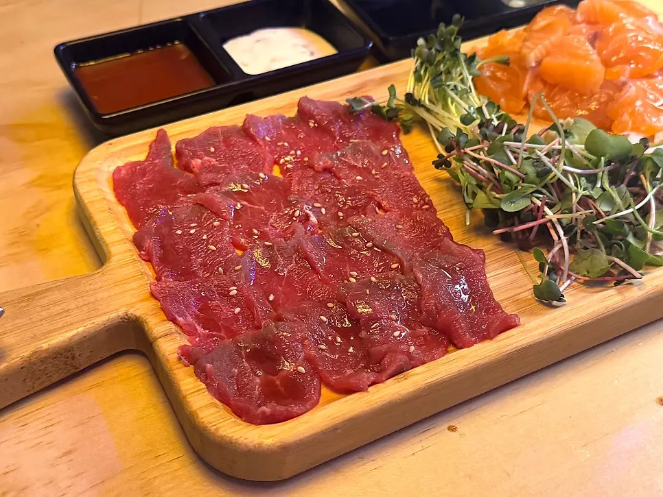 Plate of thickly sliced salmon and raw beef