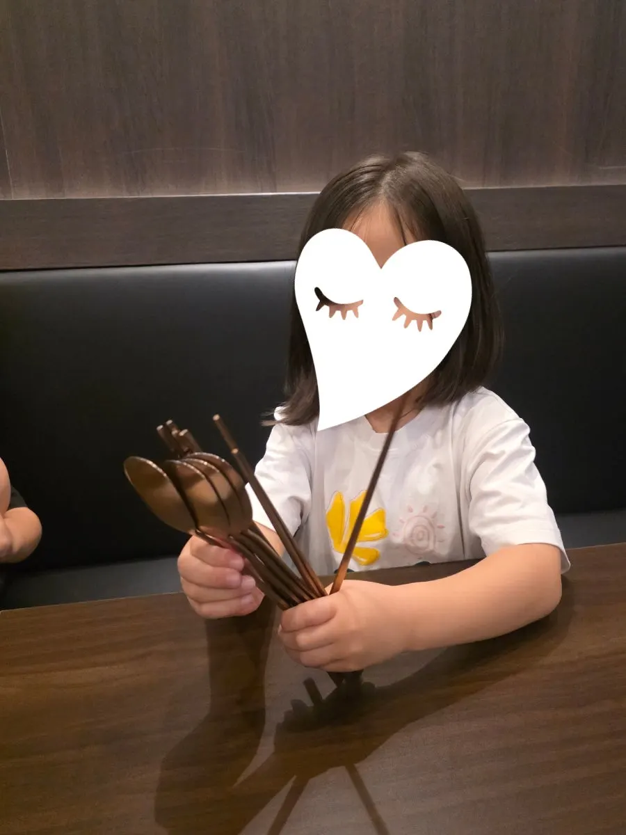Table set with spoons, chopsticks, and water cups