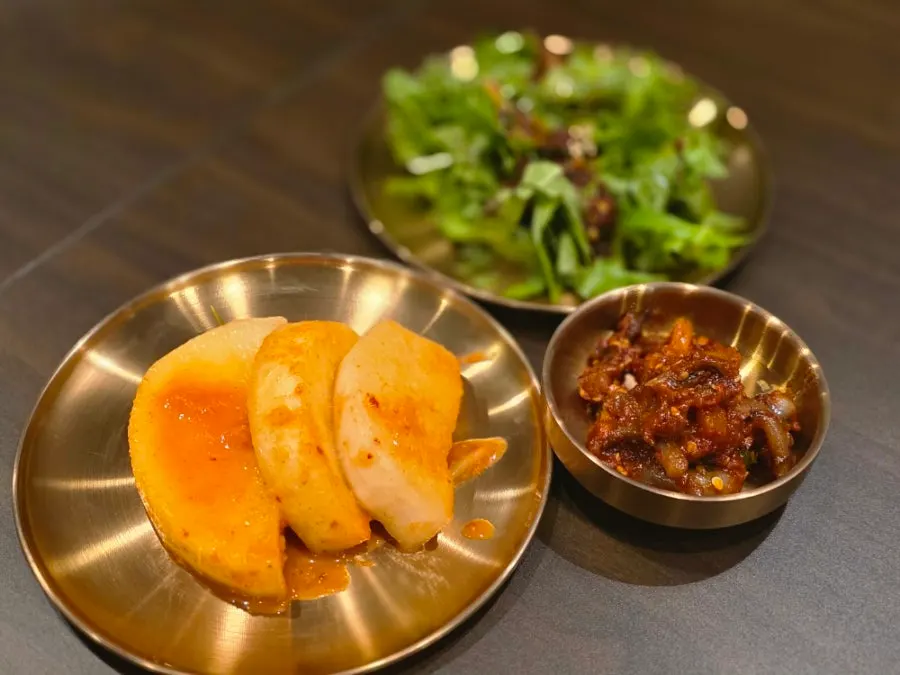 Side dishes of seasoned vegetables, seokbakji, and nakji-jeot