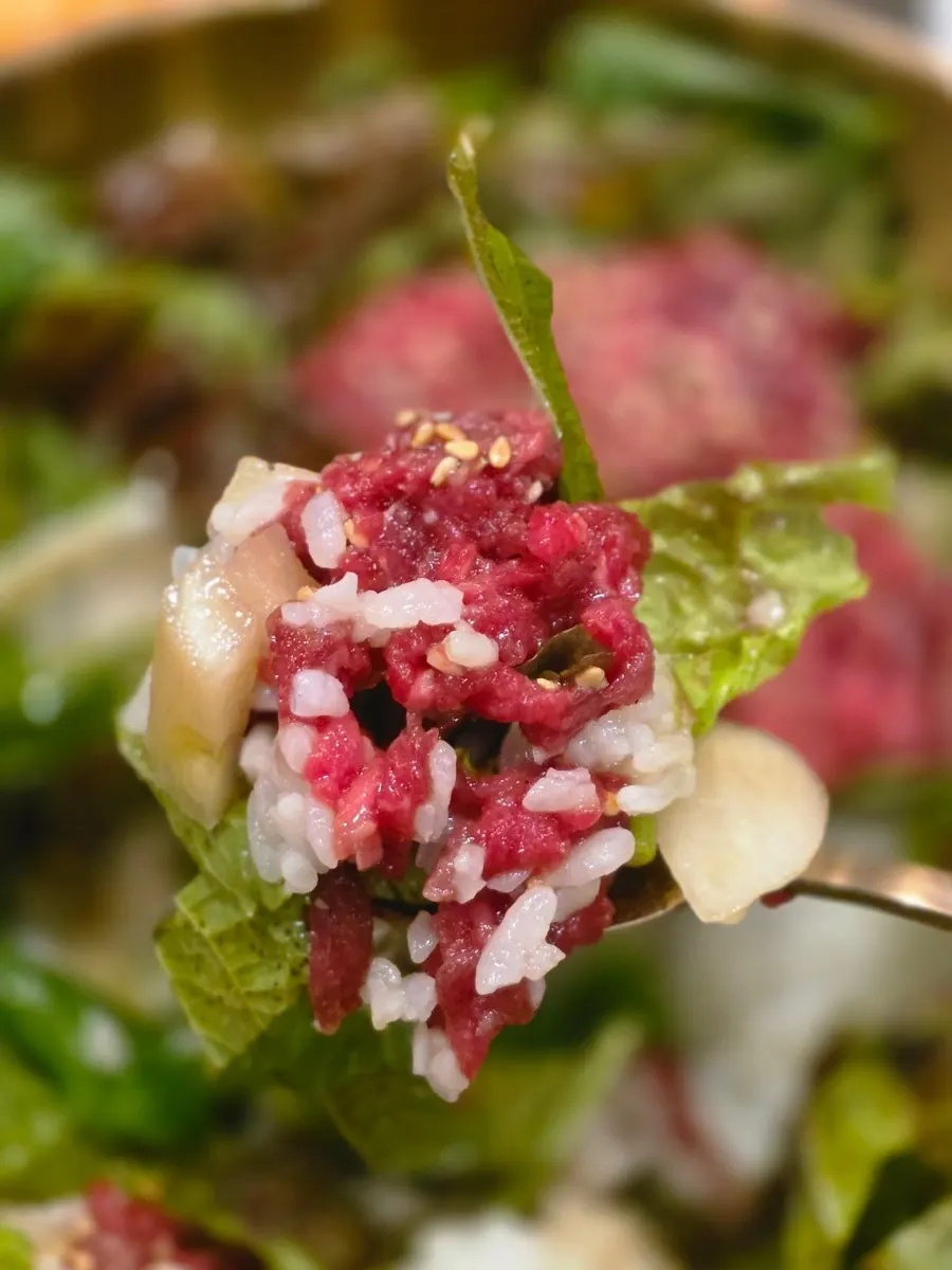 Close-up of yukhoe bibimbap topped with raw beef