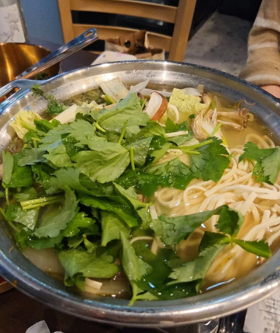 在火鍋湯底中滾煮的刀切麵