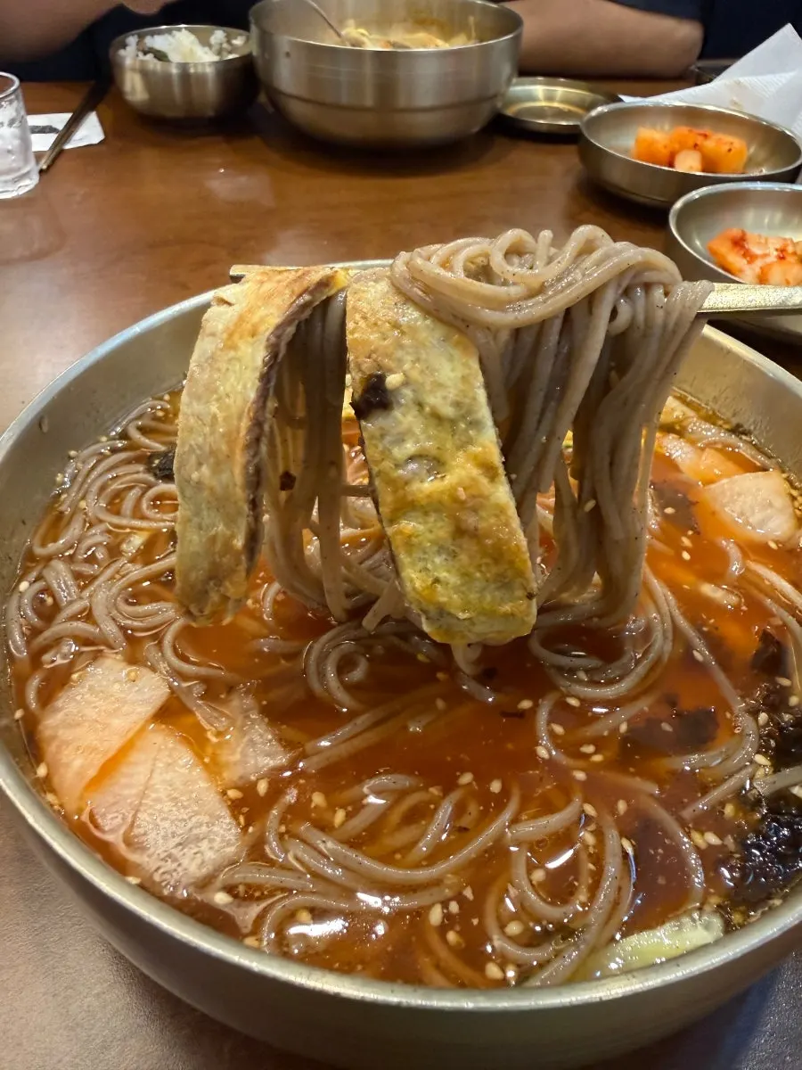 메밀면과 채 썬 육전을 함께 집은 모습