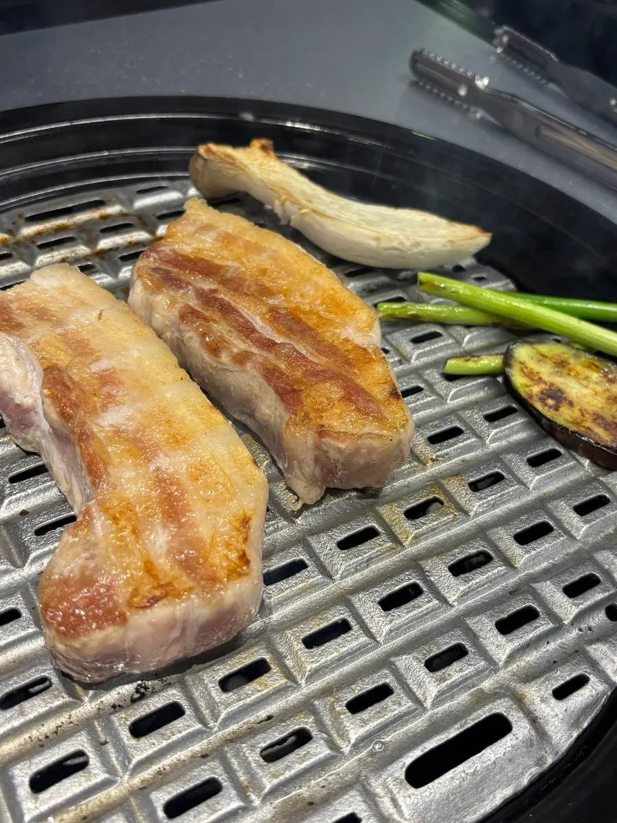 Staff grilling whole pork belly at Yukjjip