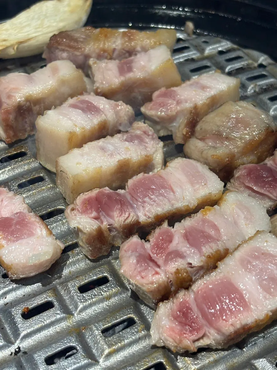 Thick whole pork belly cooking on the grill plate