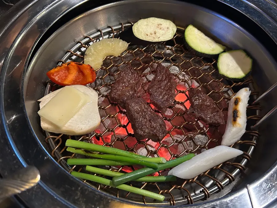 Daging lembu sedang dibakar di atas pinggan panggang