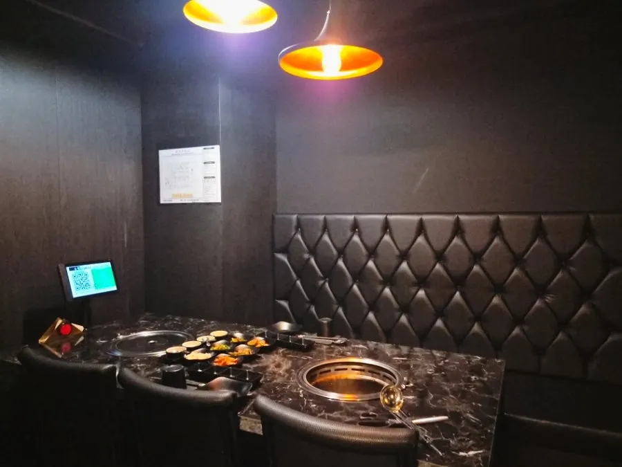 Liquor bottles displayed with lighting at the black-toned interior entrance