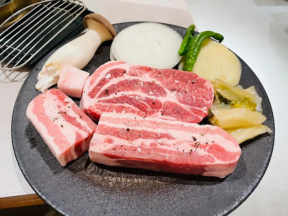 숙성생삼겹살과 숙성생목살 2인분씩 담긴 접시