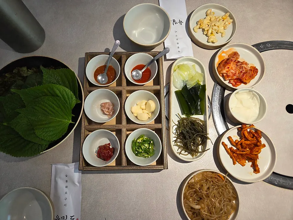 Side dishes for the ssambap jeongsik including fish cake, japchae, and perilla leaves
