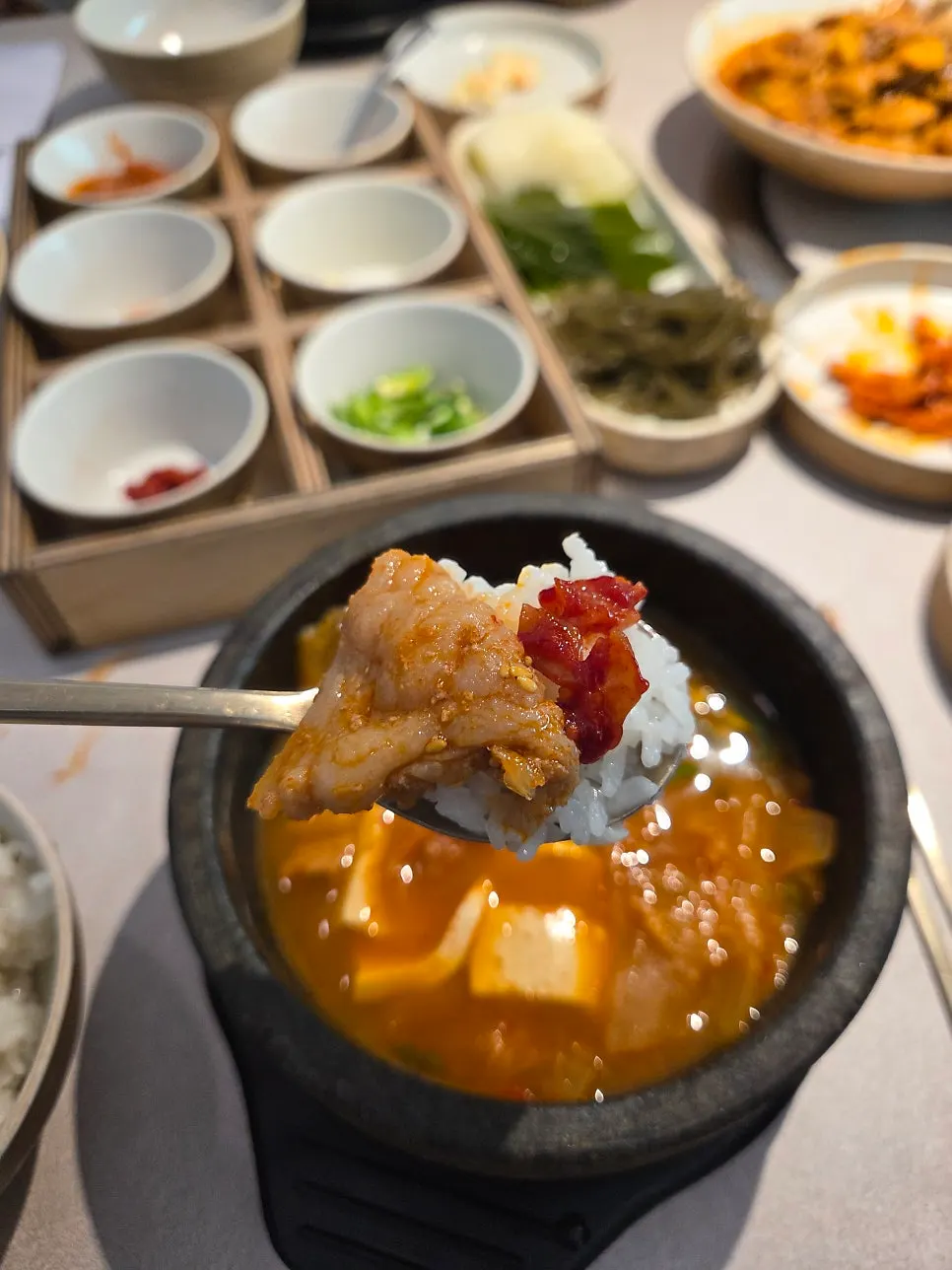 A spoonful of stir-fried pork with sotbap rice
