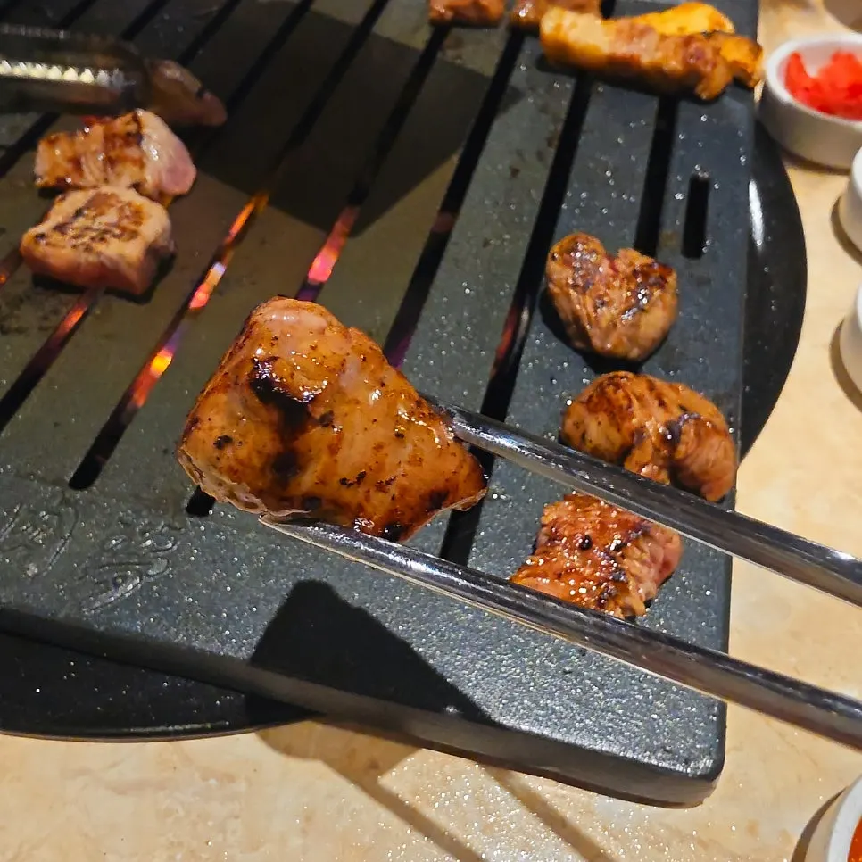 A piece of seolhwa sirloin picked up with tongs