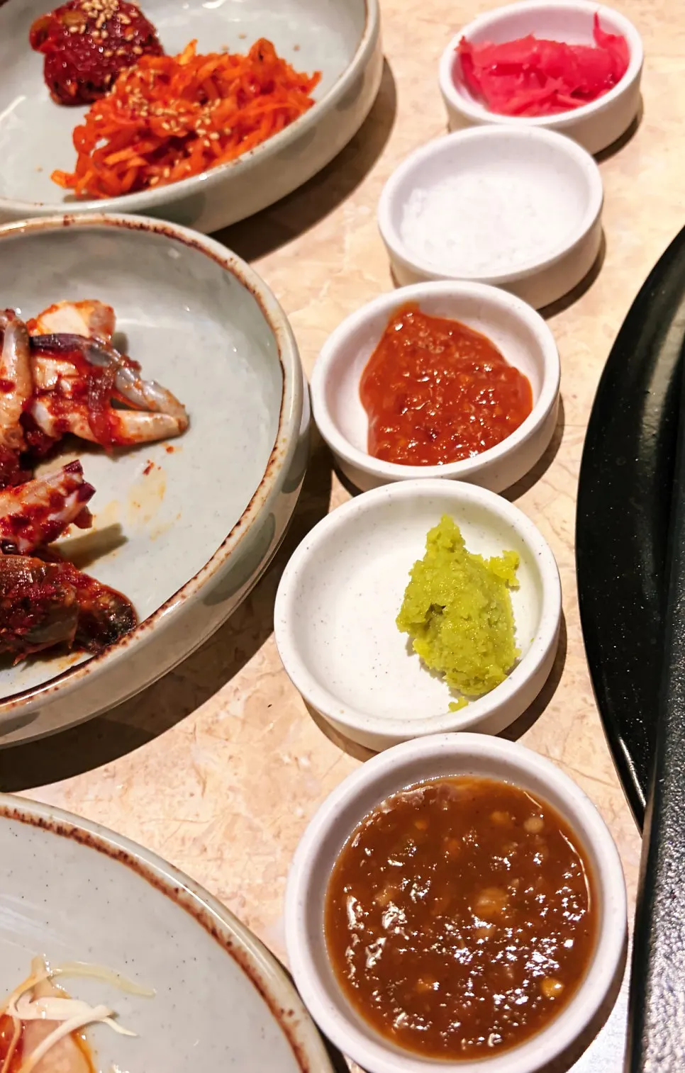 Condiments for the meat, including yuja-ginger pickle and jeotgal