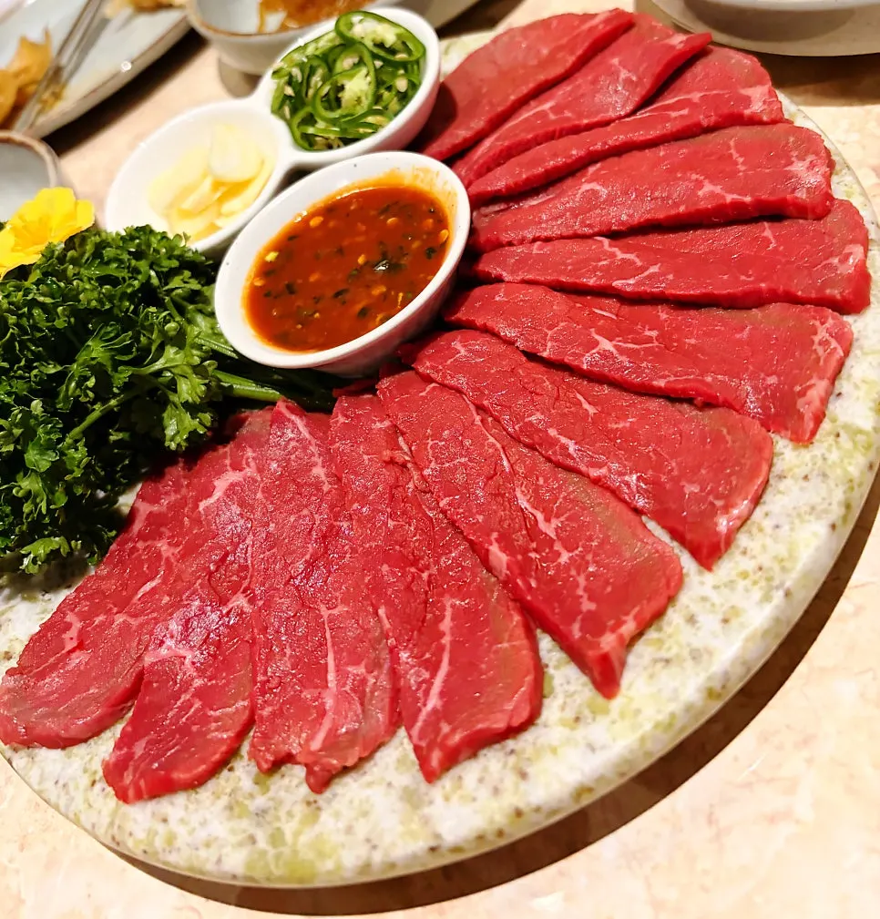 A table set with both hanwoo yukhoe and grilled Korean pork