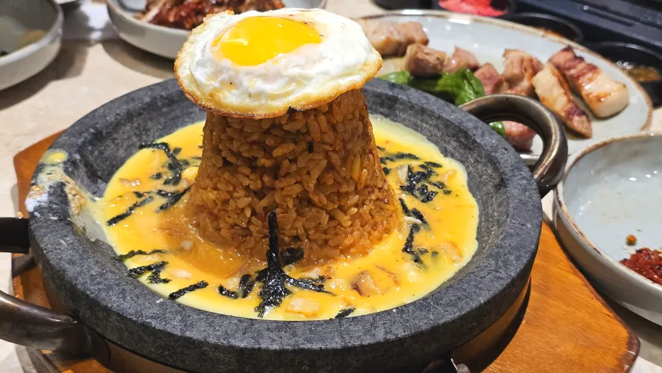 A piece of meat wrapped with lettuce and banchan