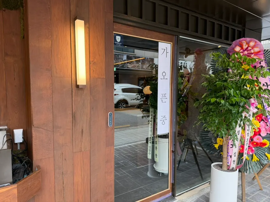Restaurant entrance with a soft-open sign posted