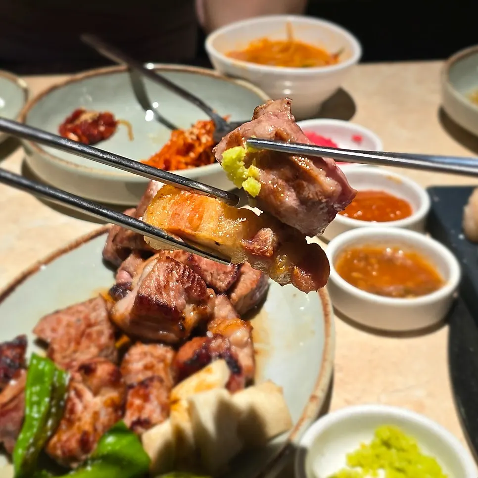 Grilled meat being dipped into sauce
