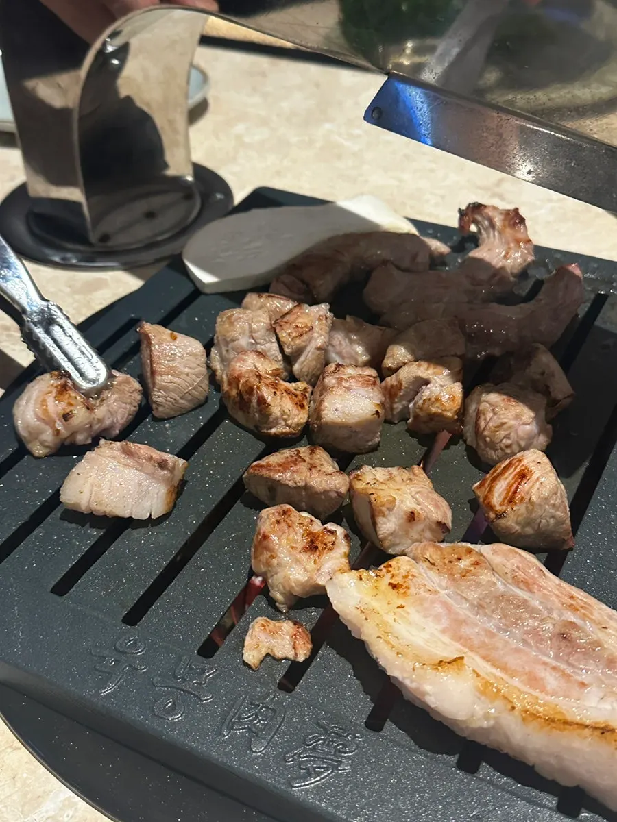 Staff member grilling meat on the plate