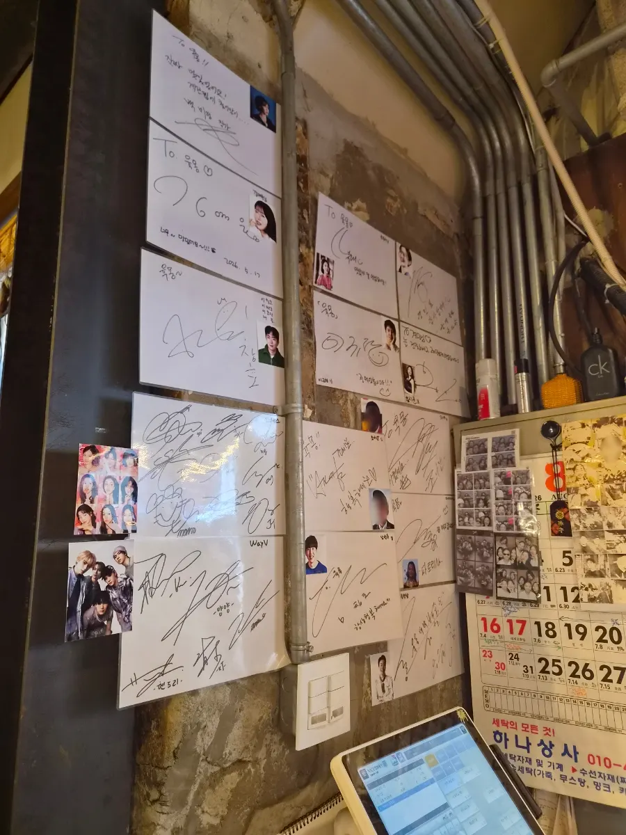 카운터 벽면에 걸린 연예인 사인