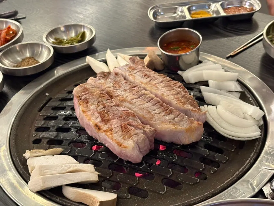 직원이 양파와 버섯을 함께 구워주는 삼겹살 불판