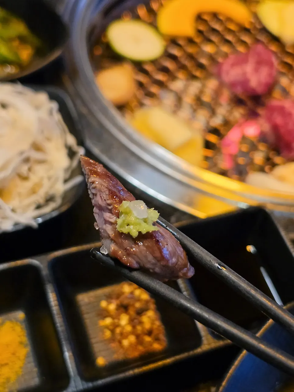 A piece of galbisal topped with wasabi and pink salt