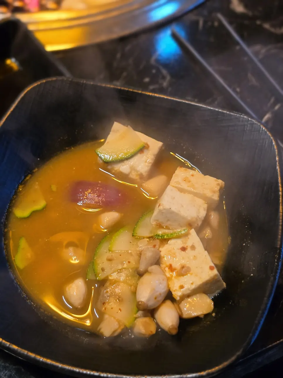Inside the doenjang jjigae, full of tofu and zucchini