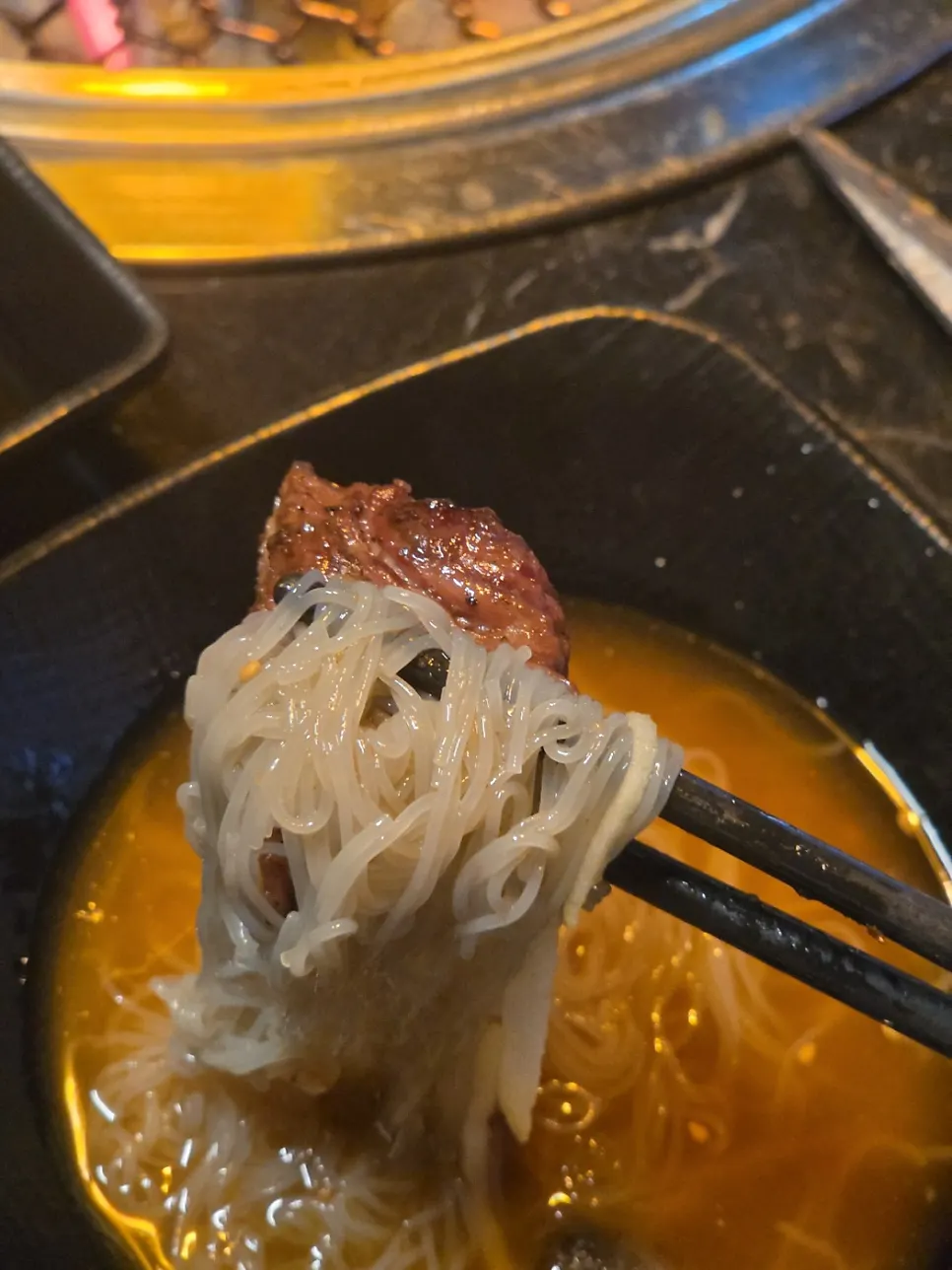 A piece of beef placed on top of the mul naengmyeon