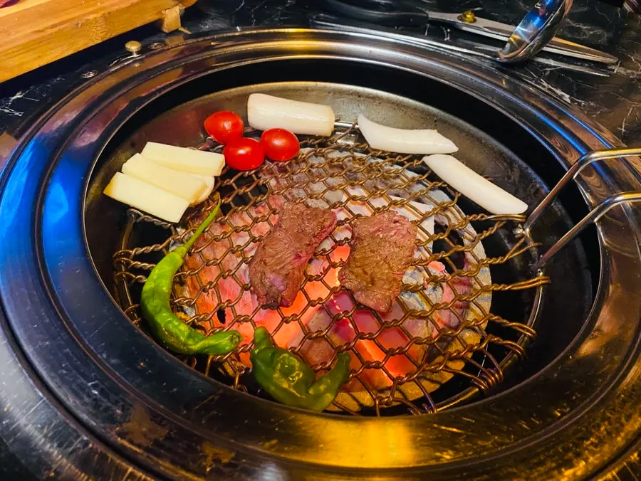 Meat being placed on the charcoal grill