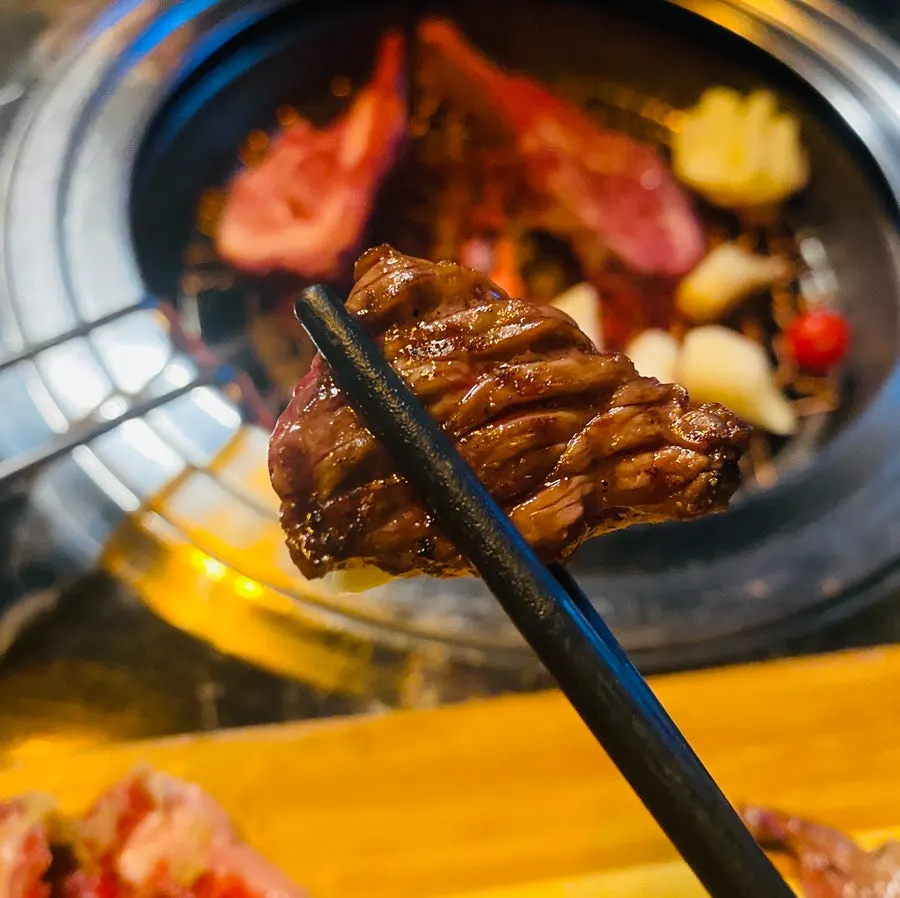 Meat and sides grilling alongside cherry tomatoes