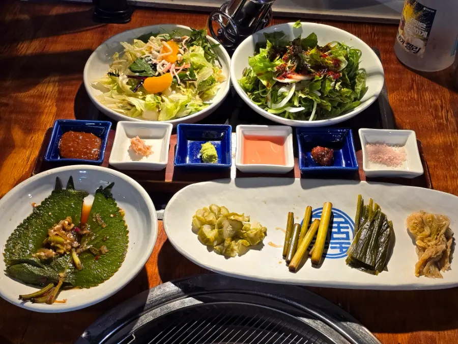 Table set with salad, mountain leeks, and other basic side dishes