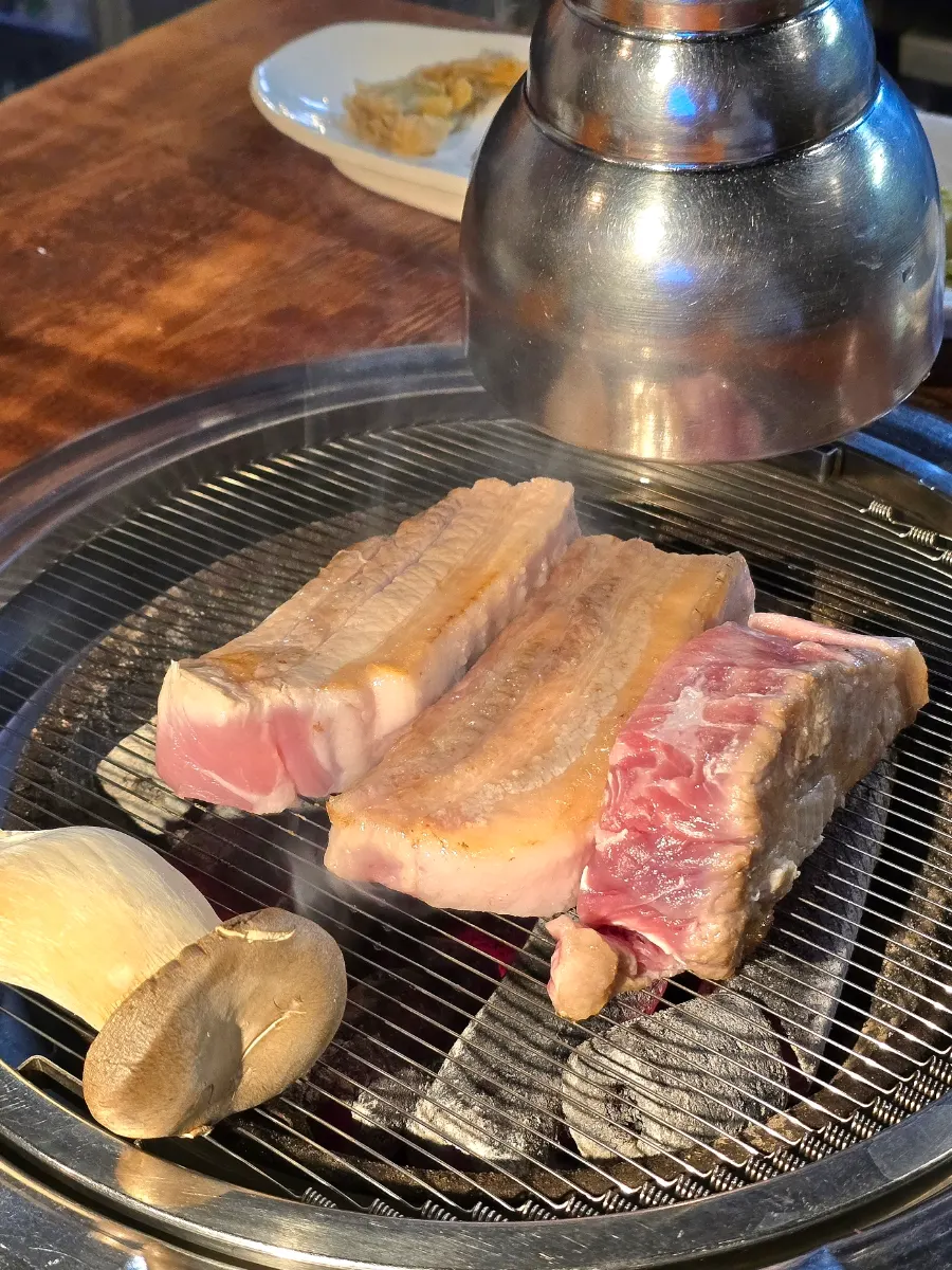 Staff member grilling meat on the charcoal grill
