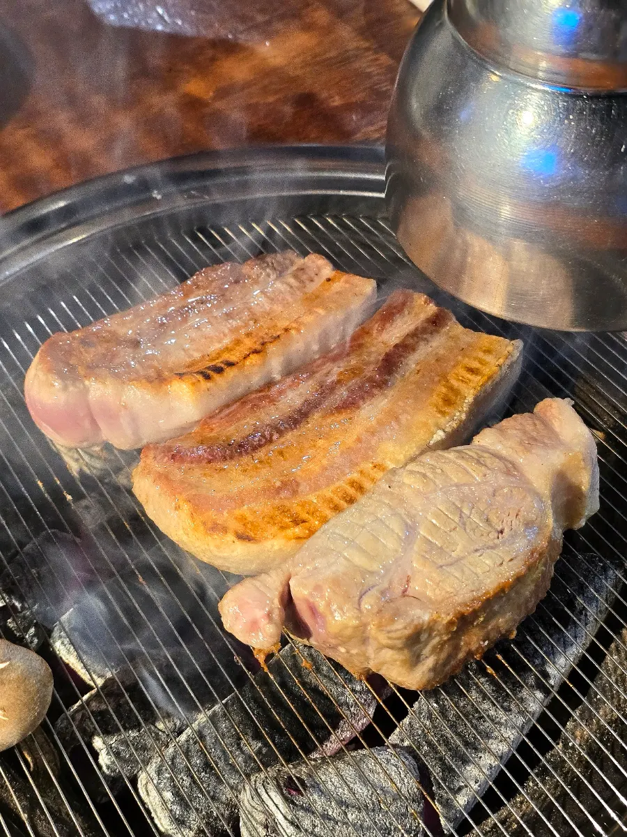 Black pork grilling to a golden brown over charcoal