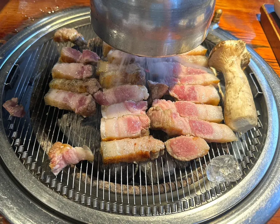 Meat grilling over charcoal at Yuk Tongnyeong Gyodae Branch