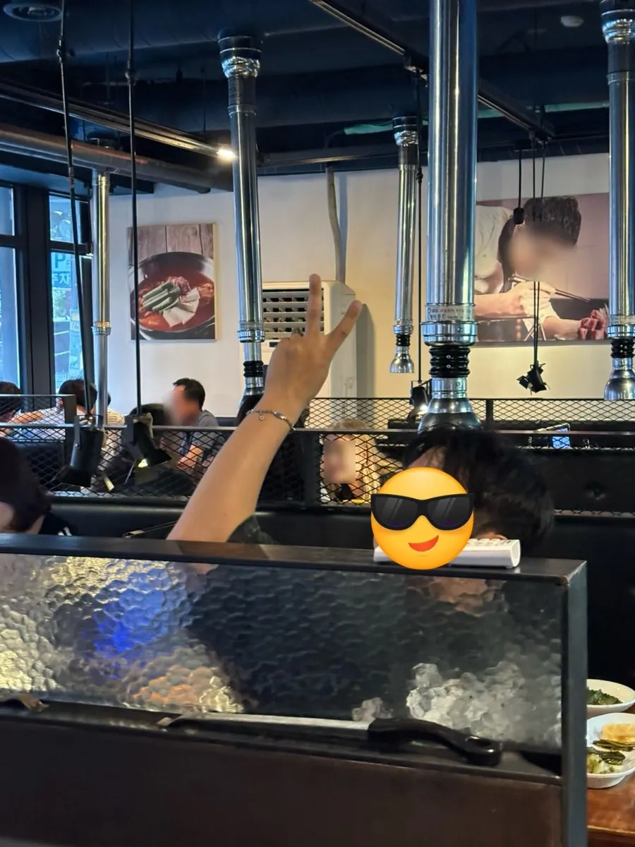 테이블에 앉아 브이 포즈를 한 일행