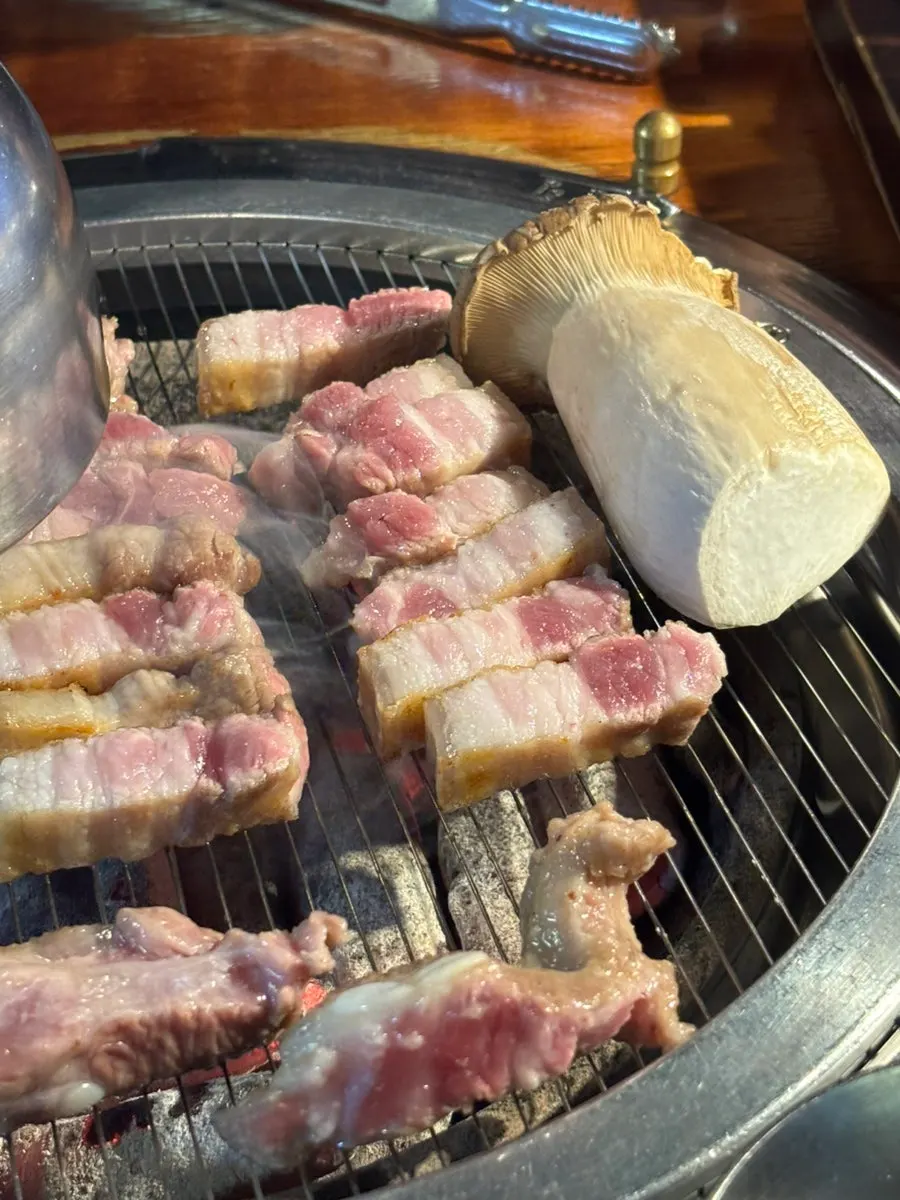 직원이 불판에서 육겹살을 굽는 모습