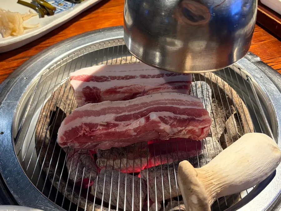 Yuk Tongryeong's basic side dishes including pickled cucumber, aged kimchi, and wild garlic leaves