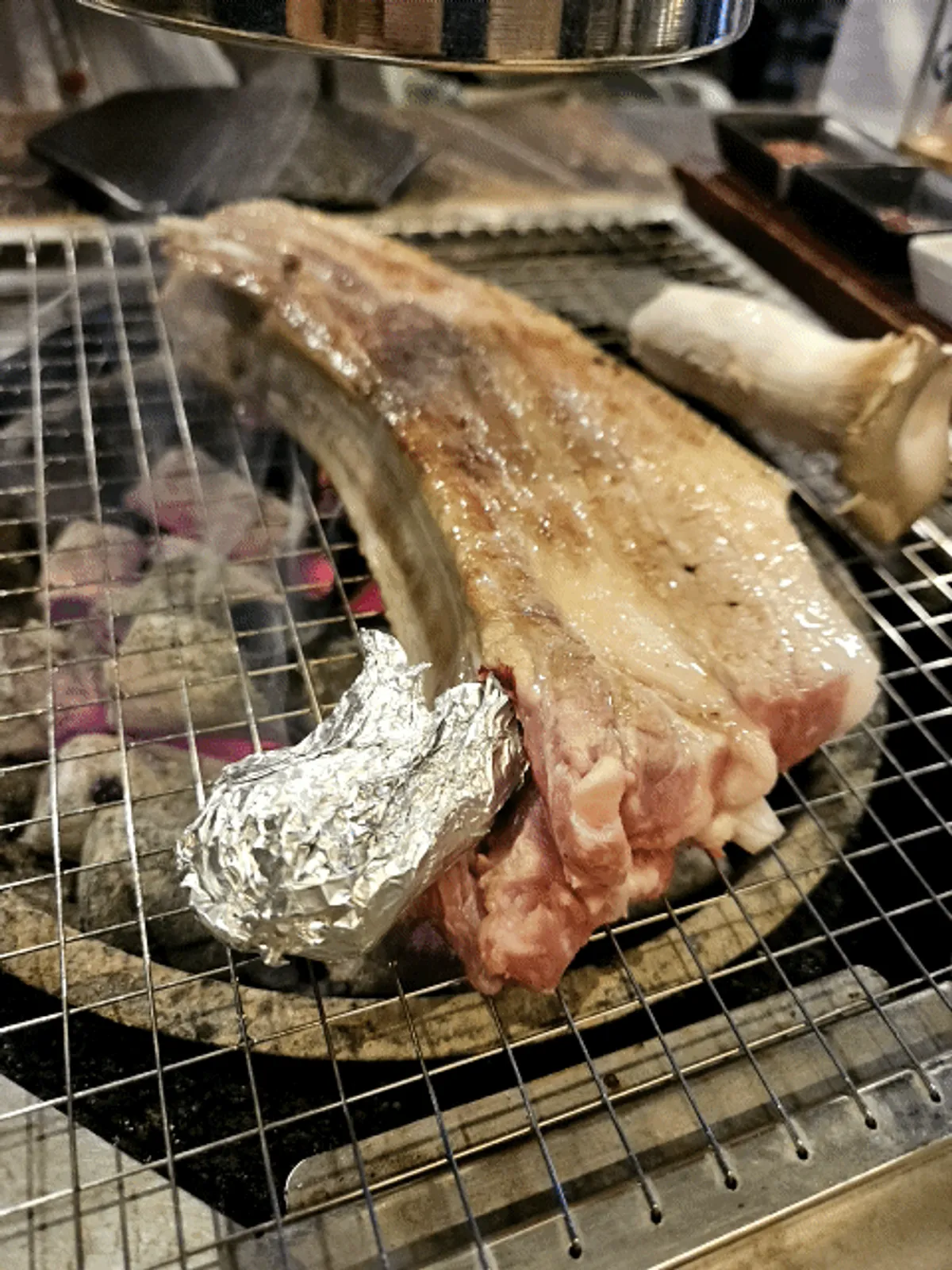 スタッフが炭火で焼く厚切りの王斧骨オギョプサル