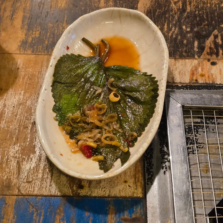 A piece of black pork wrapped with perilla leaf