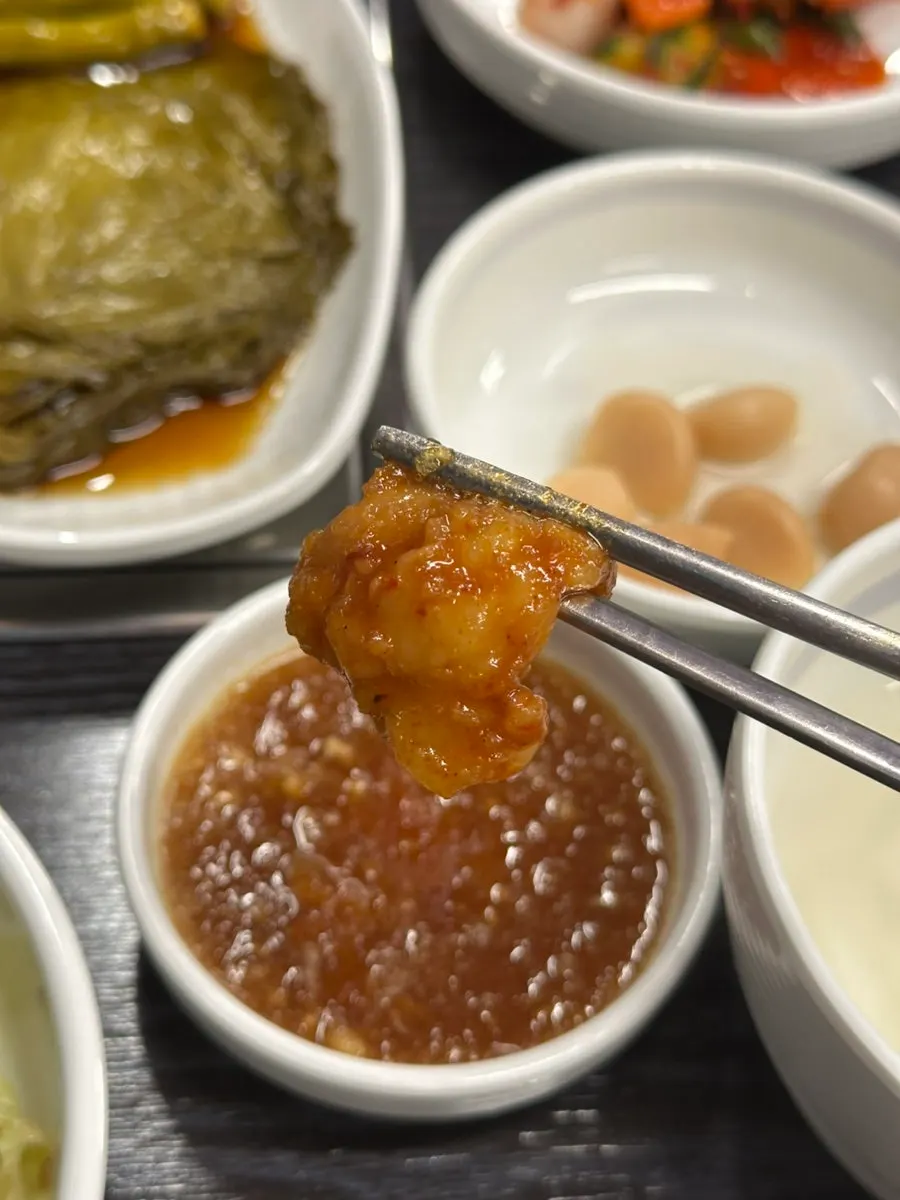 Chopsticks picking up a piece of seasoned gopchang