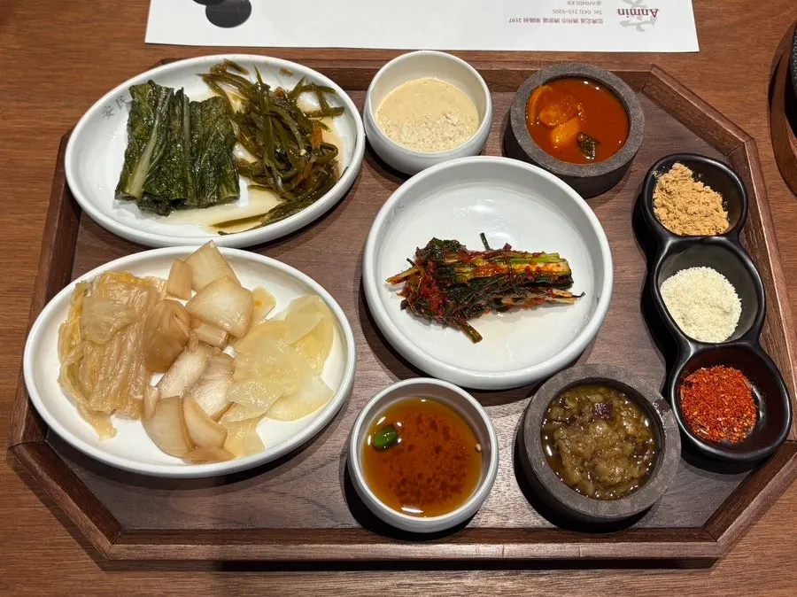 Spread of seasonal pickles, green onion kimchi, and other side dishes