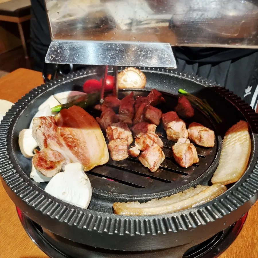 숯불 불판에서 구워지는 삼겹살과 목살