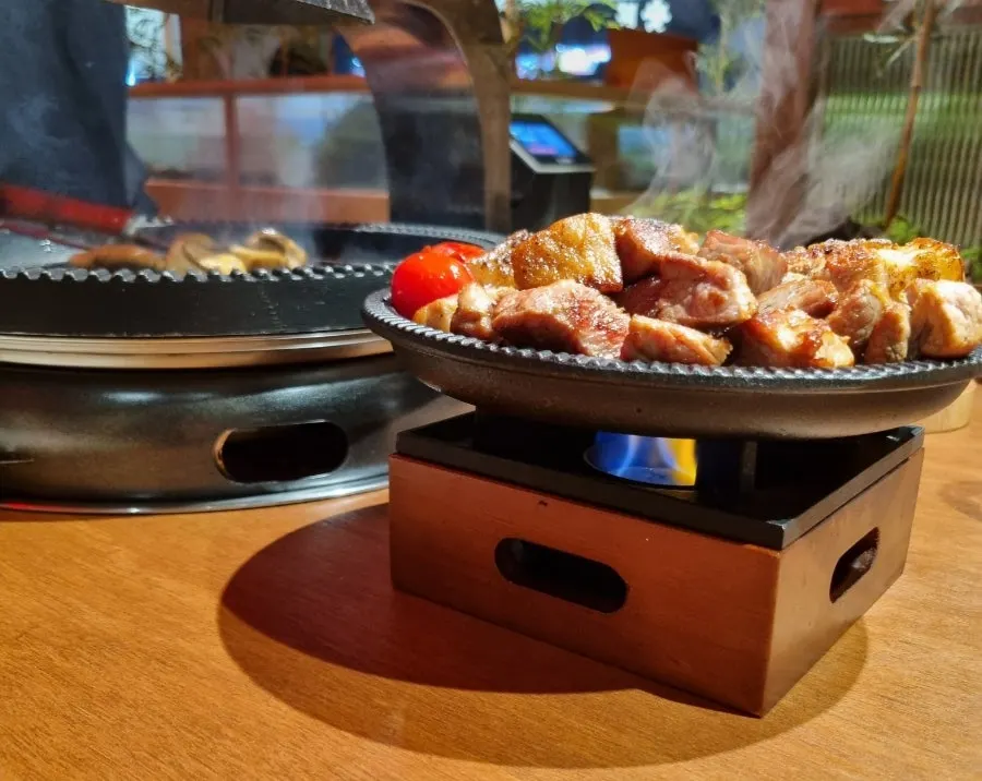 불판 테두리에 올린 야채와 굽는 고기
