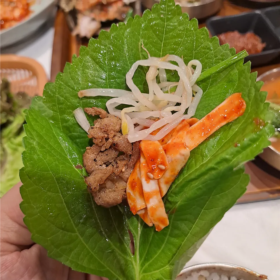 Wrapping grilled bulgogi in a lettuce leaf
