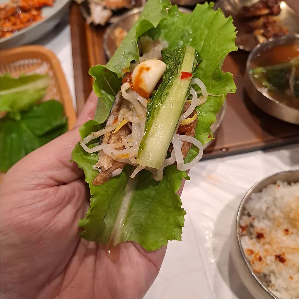 Wrapping seasoned squid in a lettuce leaf