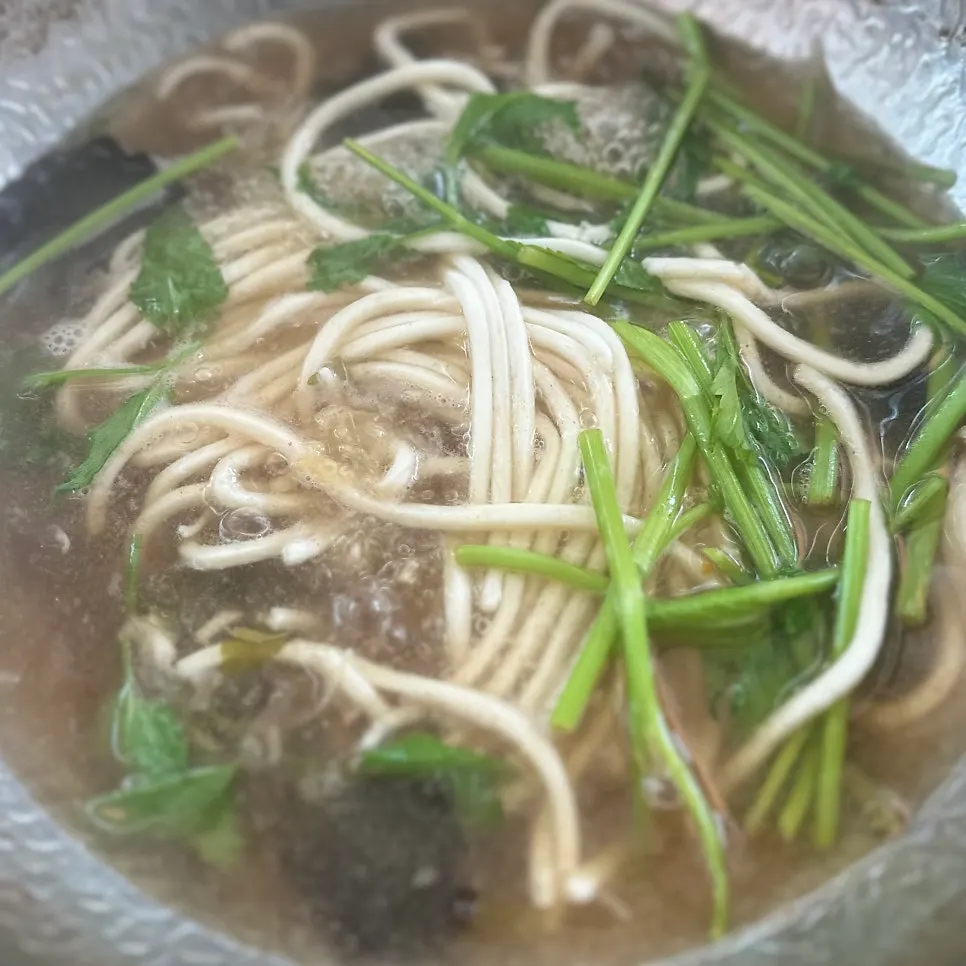 Kalguksu noodles and minari added to the broth