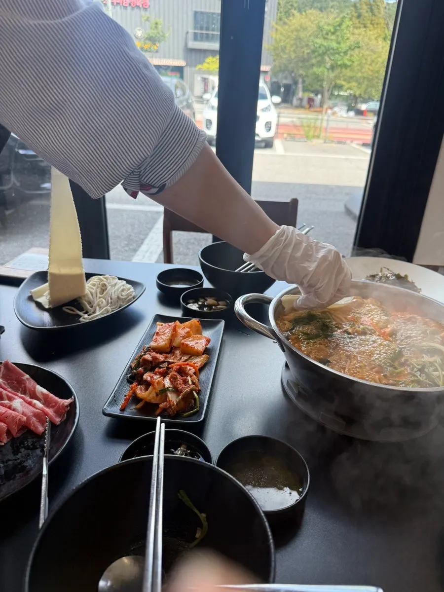 Menu board listing red and white broth shabu-kalguksu