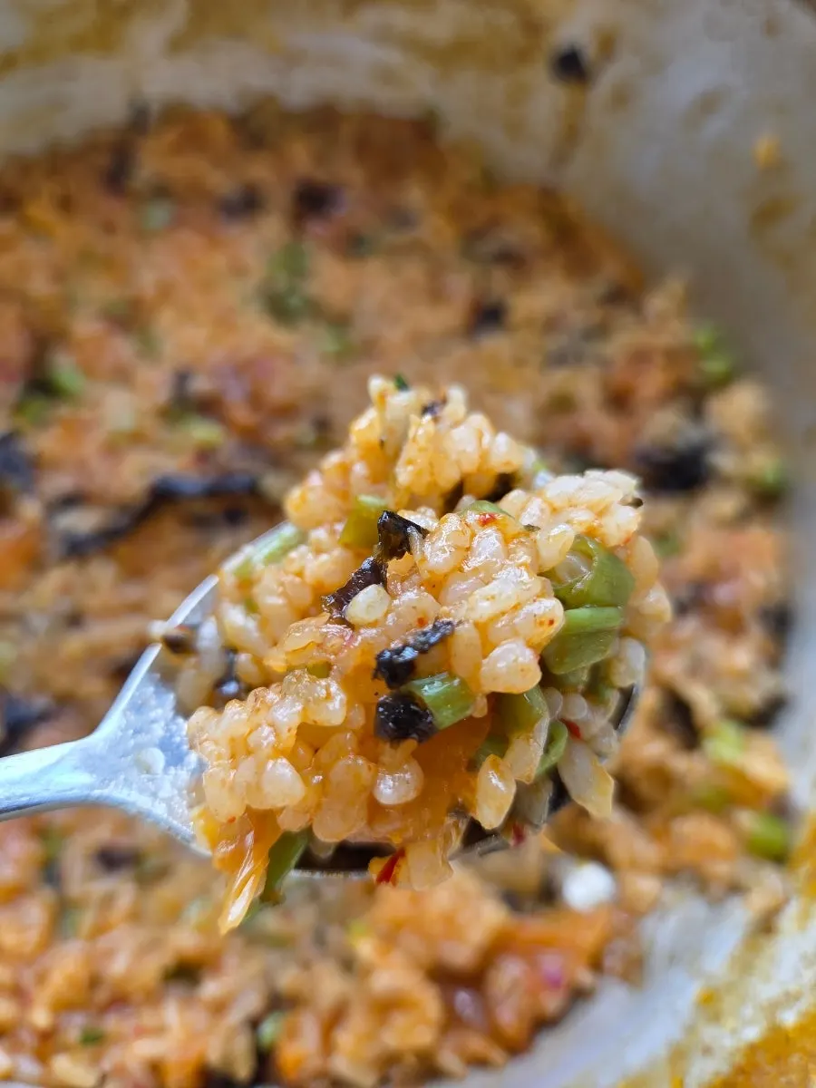 A spoonful of fried rice with spicy broth flavor soaked in