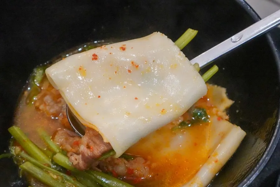 Flat kalguksu wrap dipped in the special sauce