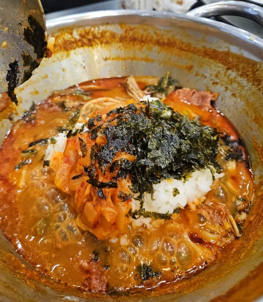 House-made kalguksu noodles being lifted out of the pot