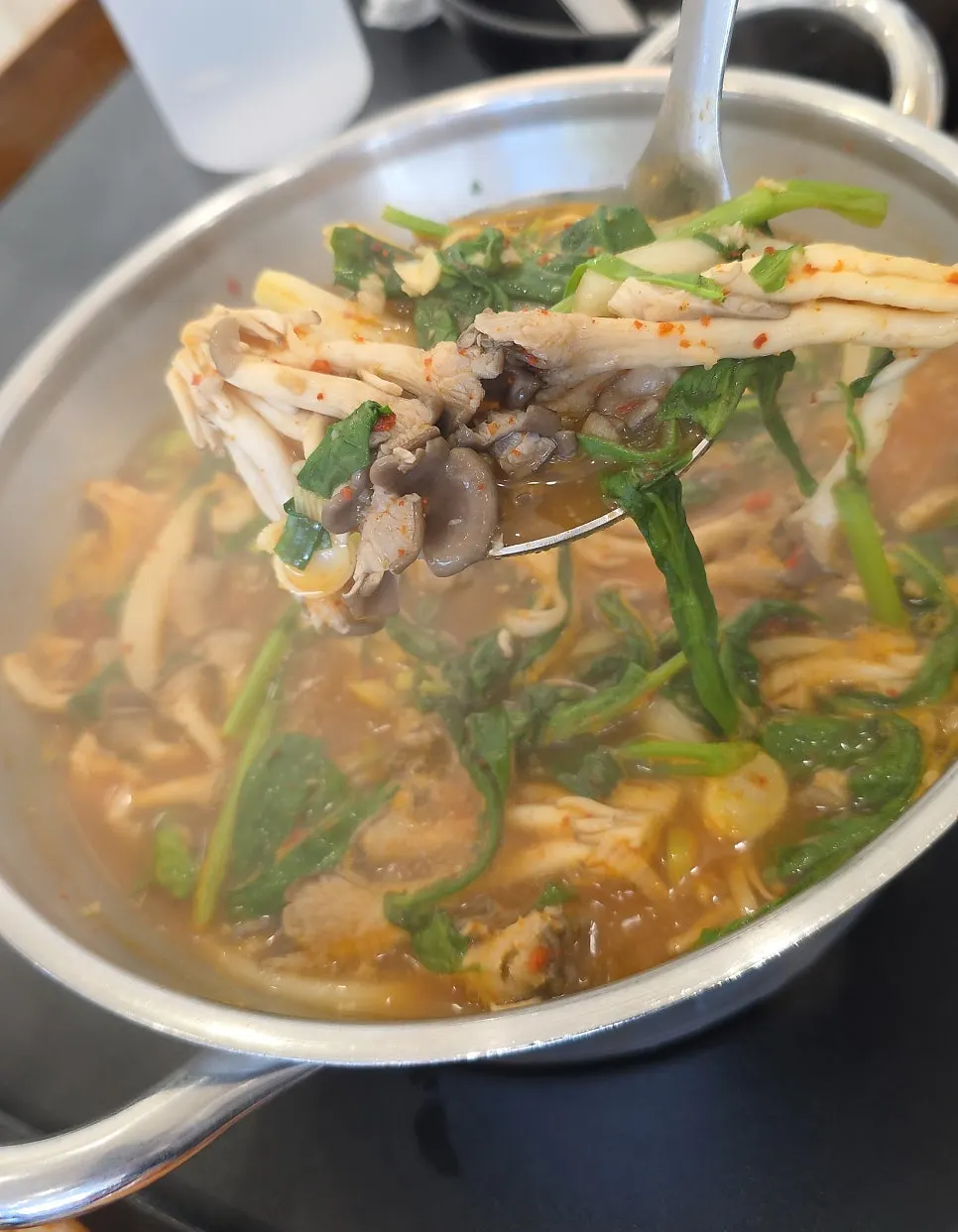 Cooking meat and vegetables in a bubbling pot of shabu-kalguksu broth
